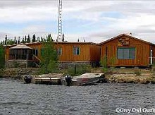 Waterfront guest cabins and fishing boats at Grey Owl Outfitters