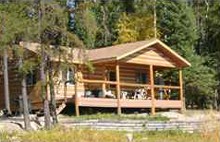 Log guest cabin with porch at Shining Falls Lodge