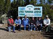 Fishermen in front of sign for Lynx Tundra Lodge